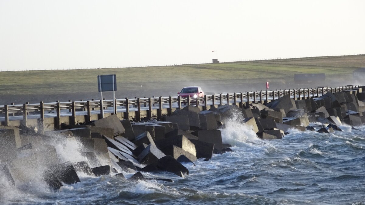 A car drives across the link road with waves